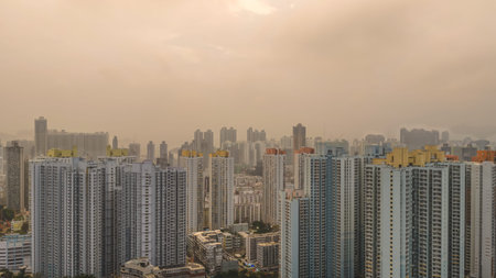 March 27 2026 High rise apartments stand against warm hazy Kowloon skyline.