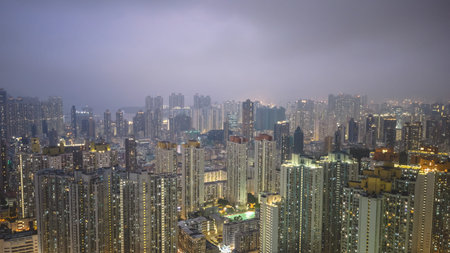 March 27 2026 High rise apartments stand against warm hazy Kowloon skyline.