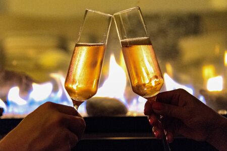 Toasting champagne by the fireの写真素材