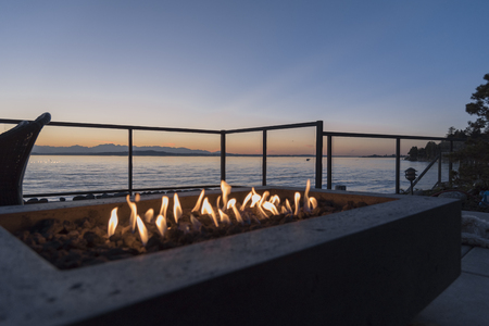 Fire pit gas lit by the sea at sunsetの写真素材