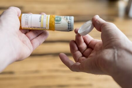 One hundred dollar bill inside pill bottle point of viewの写真素材