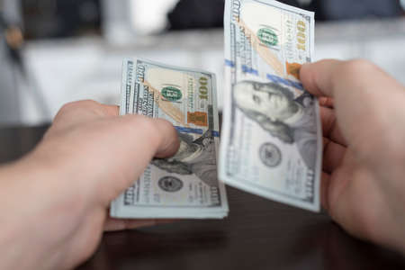 Point of view counting out one hundred dollar billsの写真素材