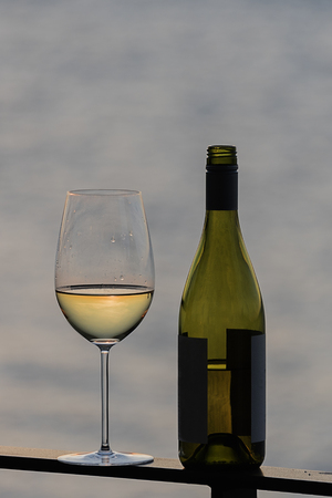 White wine with bottle by the seaの写真素材