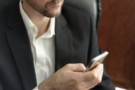 Man using smartphone in suit headlessの写真素材