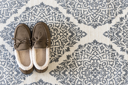 Warm slippers on patterned rugの写真素材
