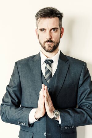 Professional businessman portrait doing zen pose with handsの写真素材
