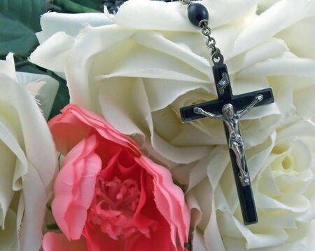a rosary cross surrounded by silk rosesの写真素材