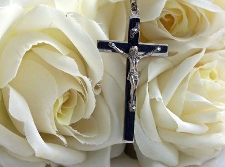 a rosary cross surrounded by white silk rosesの写真素材