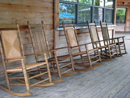 row of wooden rocking chairs on porchの写真素材