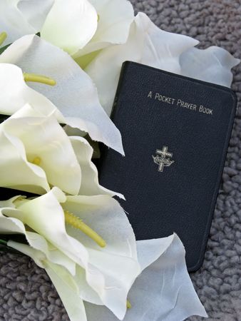 pocket prayer book with lilies, symbols of funeral ceremony