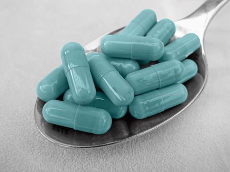 medication capsule vitamin pills sitting on spoon