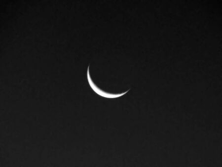 crescent moon sliver cloudless black night skyの写真素材