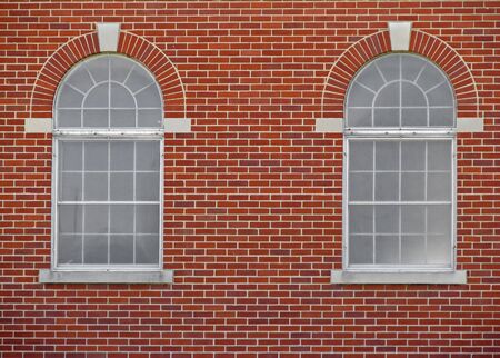 two arched windows on red brick buildingの写真素材