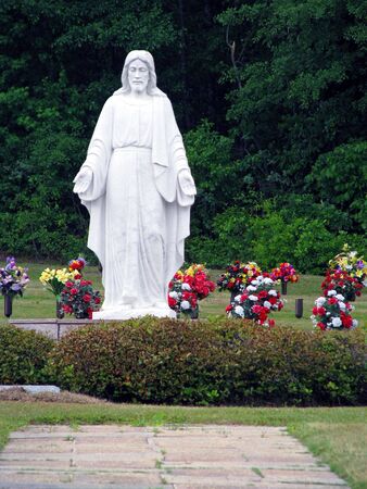 symbolic religious statue in colorful summer cemeteryの写真素材