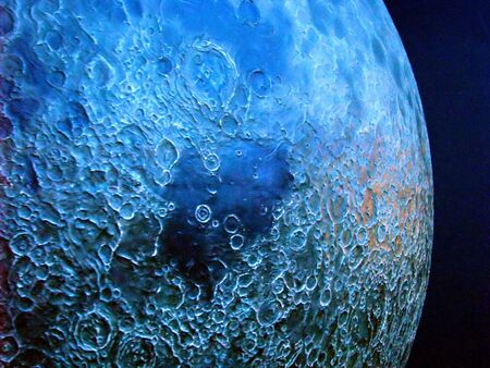 photo of moon with craters on blue background