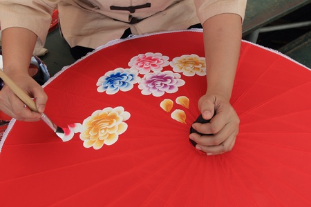 SAN KAMPHAENG, CHINA - JAN 13  Artist draws picture on umbrella, January 19,2013 At Bo Sang Village,Sankamphaeng,Chiang mai,Thailand の写真素材