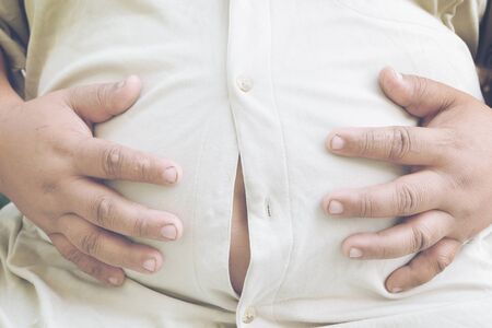 Tight shirt. man with overweight. unsuccessful dieting and eating the wrong foods. Weight loss concept.の写真素材