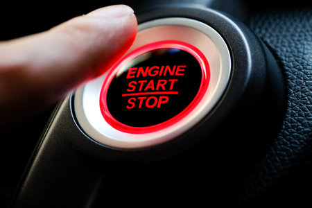 The driver's hand is pressing the car start button. Concept of transportation and technologyの写真素材