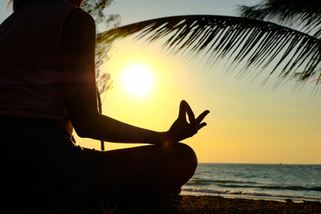 Silhouette young woman practicing yoga meditation at riverの写真素材