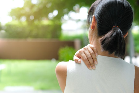 Women have neck pain, shoulder pain, at the park health concept.の写真素材