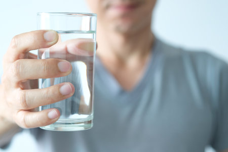 In the Morning, hand of man holding a clear glass of water for drinking.の写真素材