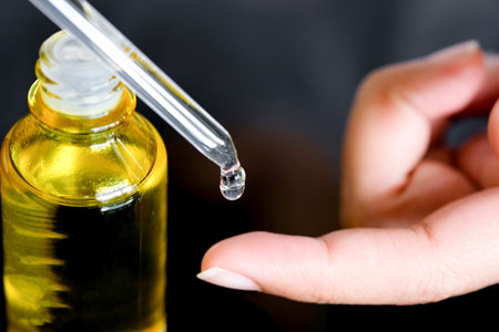 Dropping serum collagen moisturizer of face into clear yellow bottle soft light background. Protector skin Treatment facial essence oil, Vitamin C. Beauty and spa Conceptの写真素材