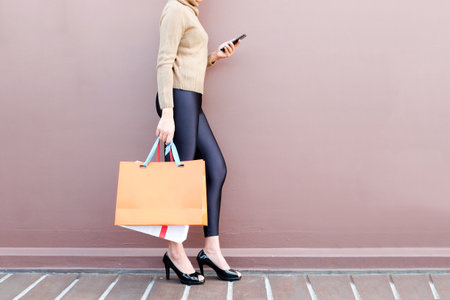 Women use smartphone shopping online , Fashion outfit stylish clothes. Carry a colorful shopping bag.の写真素材