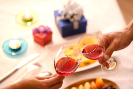 Hand of group friends celebrate successfully with red wine in the party. Young toasting in party and...