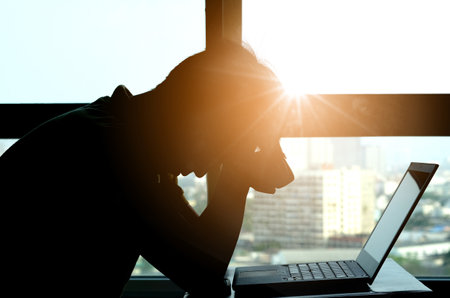 Woman sitting work computer stressed not happy at her desk . Health conceptの写真素材