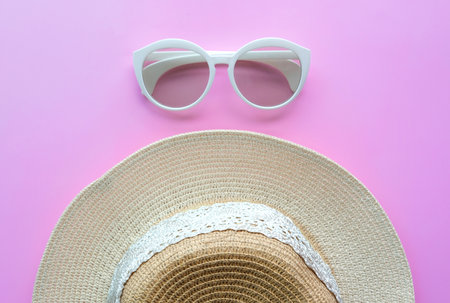 Summer fashion accessories and sunglasses and hat for travelling at beach. Pink pastel colorful background. Fashion and tourism conceptの写真素材