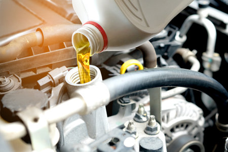 Refueling and pouring oil into the engine motor car. Energy fuel concept.の写真素材