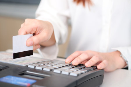 Hand of woman holding credit card She is using a Credit card machine to pay bills in the...