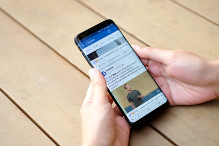February 11, 2018 Bangkok, Thailand Women use mobile internet application facebook on smartphone...