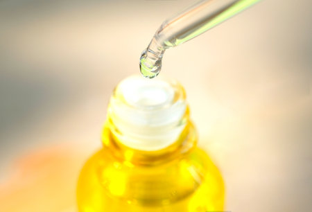 hands of a beautiful woman Dropping serum collagen moisturizer of face into clear yellow bottle soft light background. Protector skin Treatment facial essence oil, Vitamin C. Beauty and spa Conの写真素材