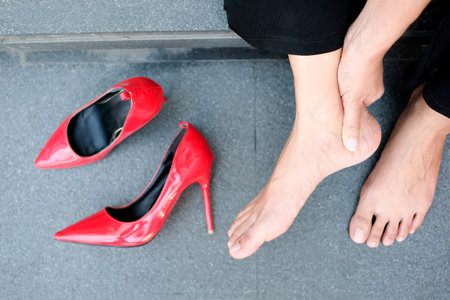 Women with leg cramps and ankles from high heels. She sat on the stairs holding her leg. and catch...