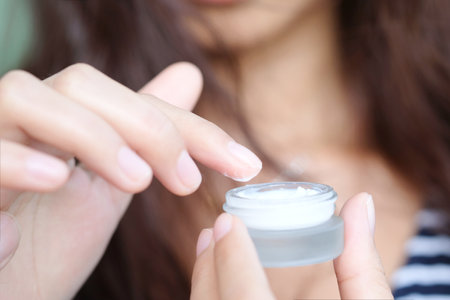 hands of a beautiful woman Dropping serum collagen moisturizer of face into clear yellow bottle soft light background. Protector skin Treatment facial essence oil, Vitamin C. Beauty and spa Conの写真素材