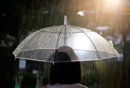 Itâs raining, Women walk in the rain. Hand of women holding an umbrella. She feel sad, Sky have a drizzling and overcast all the time. Raining background, Umbrella background.の写真素材