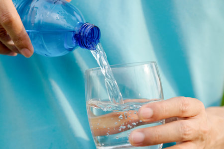 Clean water for good health. Pouring Fresh Pure Water From Pitcher Into A Glass on table wooden....
