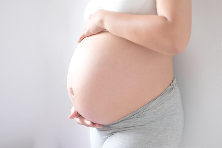 She have a baby. Woman is pregnant touching belly with love of mother and baby. Relationship during...