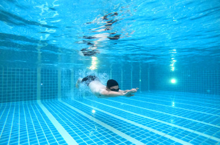Men swim in the pool He is diving