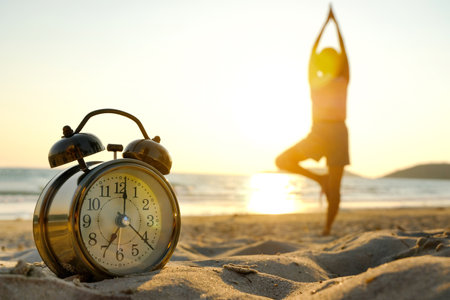 Morning of a new day, alarm clock woman playing yoga and stretching muscles on the beach sunlight in...