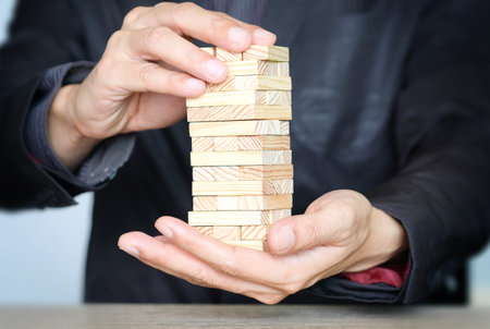 Steps of success for business or investment. Business man is arranging wood block to increase high, Business concept , Investment concept of successfulの写真素材
