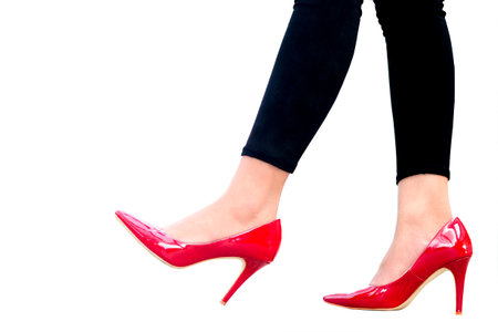 leg of woman beauty put on red high heels on isolated white background.Beauty and health conceptsの写真素材