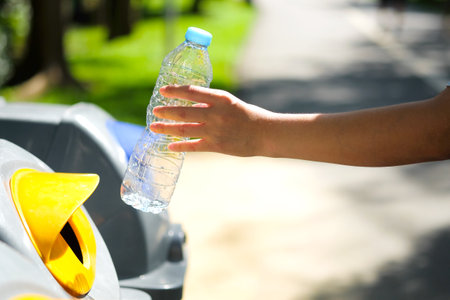 Please dispose of plastic bottle into the tank. A man throw rubbish in the trash can by separate garbage to dispose like hazardous waste ,の写真素材