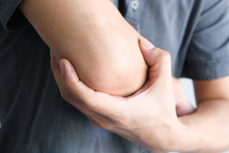 Men use their hands to hold their elbows and He had pain at the elbows.. Painful Health and medical conceptsの写真素材