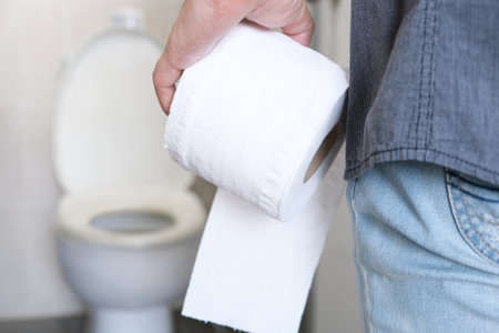 Man's hand, he holds a roll of toilet paper Going to the bathroom Toilet toilet backgroundの写真素材