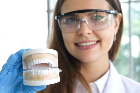 hands of a dentist, he is demonstrating how to brush your teeth properly. To clean the teeth and...