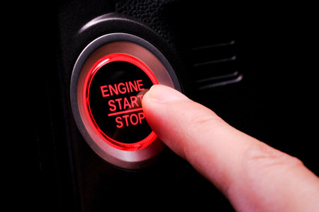 The driver's hand is pressing the car start button. Concept of transportation and technologyの写真素材