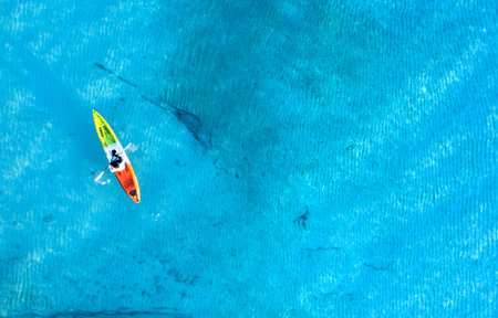 Aerial view of a kayak in the blue sea .Woman kayaking She does water sports activities.