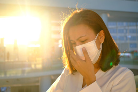 Asian woman with an active personality works in the city She wears a mask to protect against the virus. Respiratory disease. Coronavirus (covid 19) contagious by touch.の写真素材